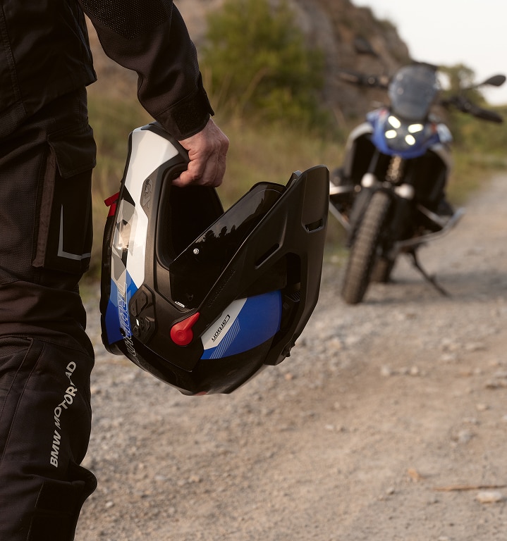 Uma pessoa está segurando um capacete de motocicleta na mão.